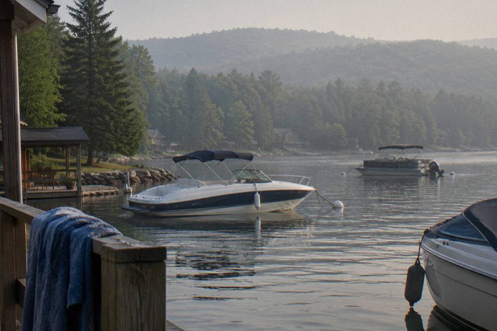 Boats anchored in a quiet cove on Deep Creek Lake with tree covered hills at the shoreline